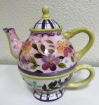 Lindo e raro conjunto em porcelana de bule e xícara com encaixe, na cor roxa e amarelo com pintura de flores. Mede: 17 x 17 cm.