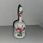 Lindo sino de mão antigo feito em porcelana Bone China, na cor  branca com detalhes dourado na borda e no topo e decoração floral com rasas e folhas verdes. Objeto decorativo ou colecionável. Mede aprox. 13,5x6 cm.