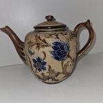 Belíssimo e raro Bule em cerâmica marca Doulton Slaters, série 4207, peça antiga provavelmente final do século XIX, feita em cerâmica de grés marrom comum da época, design florais em relevo e tons de bege e azul. Mede: 16x20 cm.