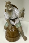 Linda escultura em porcelana chinesa, representando Chinês sentado com peixe a mão. Mede: 18x11.