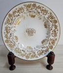 Maravilhoso prato  MONOGRAMADO, em porcelana branca com rico detalhes em relevo dourado, marca GOALPORT. Mede: 4x24,5. (suporte não incluso). 