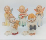 Lote com 5 anjos em porcelana, sendo 2 peças com 7 cm e 3 peças com 8 cm de altura. Figuras delicadas, representando anjos músicos e infantis, com pintura em tons suaves. Bom estado geral de conservação.