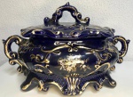 Linda compoteira em porcelana na cor azul com detalhes em dourado, com pequenos bicados. Mede: 20 x 33 cm.