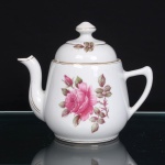 PORCELANA RAMI, Jundiaí  São Paulo (fundada em 1930). Bule em porcelana nacional, de esmaltação branca, com decoração floral em estampagem policromada, composta por rosas e folhagens em tonalidades rosa e verde. Corpo bojudo, assente sobre base circular, alça lateral arqueada e bico vertedor alongado, curvilíneo e ascendente. Tampa abobadada, encimada por pomo torneado. Frisos em douradura contornam a abertura, base, bico, alça e os elementos da tampa. Marca de manufatura PORCELANA RAMI na base. Medidas: Alt.: 16,5 x Comp.: 19 x Larg.: 12cm.