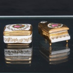 Duas(02) caixas decorativas em porcelana. Composto por caixa de formato quadrangular e caixa em forma de piano de cauda, ambas em porcelana esmaltada, com aplicação de dourado e reservas policromas representando cenas galantes, segundo repertório decorativo de inspiração rococó. A primeira apresenta tampa quadrangular com cercadura de volutas e ornatos dourados, corpo com friso floral e base realçada a ouro. A segunda, configurada como piano de cauda sobre três pés, possui tampa predominantemente dourada, medalhão policromo com casal em paisagem e reserva secundária com monograma ornamental; corpo contornado por friso dourado de motivos fitomórficos. Sem marcas de manufatura visíveis. Medidas: Alt.: x Comp.: x Larg.: ; Alt.: x Comp.: x Larg.: