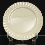 Travessa circular da linha Colorex, Companhia Vidraria Santa Marina, Brasil, c.1960-1970. Confeccionados em vidro opalino, de tonalidade marfim, aba canelada em relevo e bordo ondulado. No reverso, marca moldada IND. BRAS. Colorex S.M. MARCA REG., acompanhada de numeração de molde. A marca Colorex foi lançada pela Companhia Vidraria Santa Marina em 1961, integrando a produção de utensílios domésticos em vidro opalino difundida nos lares brasileiros durante as décadas de 1960 e 1970. Medida: Diam.: 31cm.