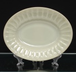 Travessa oval da linha Colorex, Companhia Vidraria Santa Marina, Brasil, c.1960-1970. Confeccionados em vidro opalino, de tonalidade marfim, aba canelada em relevo e bordo ondulado. No reverso, marca moldada IND. BRAS. Colorex S.M. MARCA REG., acompanhada de numeração de molde. A marca Colorex foi lançada pela Companhia Vidraria Santa Marina em 1961, integrando a produção de utensílios domésticos em vidro opalino difundida nos lares brasileiros durante as décadas de 1960 e 1970. Medidas: Comp.: x Larg.:
