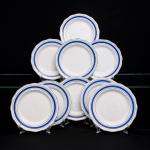 Fábrica de Louças Santa Cruz, Taubaté - São Paulo. Conjunto de dez(10) pratos rasos em faiança nacional, esmaltação branca, aba moldurada e bordo recortado em segmentos, decoração composta por faixa em azul cobalto, delimitada por filetes dourados paralelos e arremate do contorno no mesmo acabamento. No reverso, marca de fábrica em verde com coroa sobre escudo, cruz ao centro e inscrição Santa Cruz  Porcelana, acompanhada do número de padrão 55. Um exemplar apresenta lascado no bordo, conforme registro fotográfico. Medida: Diam.: 19cm.
