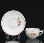 Porcelana Pozzani, Jundiaí - SP (Fundada em 1934 por Francisco Pozzani). Xícara para chá em porcelana nacional,  esmaltação branca, bojo hemisférico moldado com gomos radiais, e alça lateral estilizada. Decoração floral em estampagem policromada composta por ramagens com flores em tonalidades de laranja, amarelo, cinza e azul, entremeadas por folhagens verdes. Filetes dourados delimitam a borda. Pires com motivo floral correspondente e acabamento a ouro. No verso, marca de manufatura em verde com as inscrições Pozzani  Jundiaí. Medidas: Alt.: 4,5 x Comp.: 10 x Larg.: 8cm. ; Pires: Diam.: 14cm.