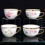 Conjunto de quatro(04) xícaras para chá em porcelana, de diferentes manufaturas. Bojo hemisférico e asas laterais estilizadas, reunindo exemplares com distintas composições florais policromadas. Duas apresentam buquês de rosas e flores em rosa, azul e amarelo; outra recebe representação de orquídea em tonalidades róseas; a quarta, ramos com flores campanuladas e pequenos elementos em vermelho. Bordos e asas ornamentados com douradura. Respectivas marcas de manufatura ao fundo. Medidas: Alt.: 5,5 x Comp.: 10,5 x Larg.: 8,5cm.