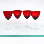 Conjunto de taças de pé alto em vidro, bojo tonalidade vermelho-rubi, haste tubular e base circular incolores. Composto de quatro(04) unidades. Medidas: Alt.: x Diam.: