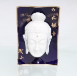 Placa devocional em porcelana chinesa representando Guanyin. Peça de formato retangular, revestida por esmalte azul-cobalto, com contorno suavemente ondulado e filetes dourados, apresentando ao centro máscara em alto-relevo de Guanyin(Avalokitevara), bodhisattva associado à compaixão no budismo do Leste Asiático. A representação exibe semblante contemplativo, olhos semicerrados, lóbulos auriculares alongados, urna assinalada na fronte e cabelos reunidos em coque elevado, ornado por diadema com motivos florais. Fundo com inscrições caligráficas douradas: Báiyi Guanyin, correspondente a Guanyin de Vestes Brancas, e Shèngshan, Montanha Sagrada. Verso com armação metálica destinada à fixação na parede. Medidas: Alt.: 17,5 x Comp.: 12 x Larg.: 6,5 cm.