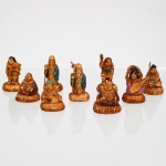 Conjunto de nove(09) figuras em resina moldada e parcialmente policromada, representando personagens pertencentes ao repertório iconográfico dos Shichifukujin, os Sete Deuses da Fortuna da tradição japonesa, com repetições de determinados tipos. Identificam-se, entre outros, Hotei,  Daikoku, Benzaiten, Jurojin/Fukurokuju; e personagens associados a Ebisu e Bishamonten. Figuras assentadas sobre bases moldadas. Medidas maior: Alt.: 6 x Comp.: 3 x Larg.: 2cm.Medidas menor: Alt.: 4 x Comp.: 4 x Larg.: 3cm.