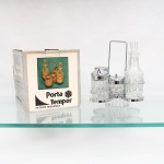 Conjunto para temperos em vidro prensado e metal cromado. Porta Temper. Composto por suporte metálico com alça superior e alojamentos para cinco recipientes: dois frascos com rolhas moldadas destinados a azeite e vinagre, dois recipientes com tampas perfuradas para sal e pimenta e pote central com tampa e colher para condimentos. Corpos em vidro incolor prensado, com decoração geométrica. Acompanha embalagem original Porta Temper. Medidas suporte: Alt.: 18,5 x Comp.: 18,5 x Larg.: 18,5cm.Medidas frasco: Alt.: 15 x Diam.: 5cm.Medidas paliteiro: Alt.: 8,5 x Diam.: 4,5cm.Medidas: Alt.: 7,5 x Diam.: 4,5cm.Medidas: Alt.: 5,5 x Diam.: 5,5cm.