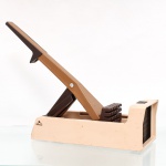 Cortador manual de batatas e legumes, modelo Iguatemi, fabricação nacional, manufatura Vulcão S/A. Estrutura em material plástico moldado nas tonalidades bege e castanho, com mecanismo articulado acionado por alavanca. A extremidade frontal incorpora grelha de lâminas metálicas destinada ao corte uniforme de batatas e outros vegetais em bastões. O braço móvel atua sobre conjunto de pressores segmentados, conduzindo o alimento contra a matriz cortante. Apresenta pés com apoios circulares e dispositivo lateral de fixação. Conserva caixa original de fábrica, identificada "Cortador de Batatas Iguatemi" e marca Vulcão, com indicação de utilização também no preparo de vinagrete, picles e legumes. Mantém etiqueta de controle de qualidade da Vulcão S/A  Indústrias Metalúrgicas e Plásticas, com numeração de série. Sinais de uso e alterações cromáticas compatíveis com armazenamento. Medidas: Alt.: 34 x Comp.: 9,5 x Larg.: 8,5cm.