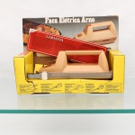Faca elétrica da marca Arno, aparelho doméstico para corte de carnes, pães, frutas e outros alimentos, com corpo em material sintético nas tonalidades bege e castanho, empunhadura superior e acionamento por botão. Provida de conjunto de lâminas metálicas serrilhadas removíveis. Identificação moldada na base: "Arno S/A - Indústria Brasileira", modelo FEA, série CH, potência de 135 W, frequência 50/60 Hz e tensão 127 V. Acompanha embalagem original, documentação de garantia e lâminas. Sem uso. Não foi testada, sem garantias de funcionamento. Medidas: Alt.: 44 x Comp.: 9,5 x Larg.: 7cm.