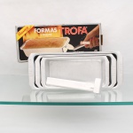 Conjunto de três formas retangulares em alumínio, marca Trofa. Composto por três recipientes de tamanhos graduados, destinados ao preparo de pães, bolos e assados, com bordas planas e marca "TROFA" gravada no metal. Acompanha pegador universal e embalagem original identificada "Formas Trofa - 3 peças - com pegador universal". Medidas pegador: Alt.: 19,5 x Comp.: 4,5 x Larg.: 4,5cm.Medidas: Alt.: 5,5 x Comp.: 23 x Larg.: 11cm.Medidas: Alt.: 6,5 x Comp.: 28 x Larg.: 12cm.Medidas: Alt.: 7,5 x Comp.: 32,5 x Larg.: 12,5cm.