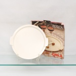 Bandeja circular em material plástico, marca Cipla; moldada em tonalidade marfim, de formato circular, com fundo plano, bordo elevado e duas pegas laterais integradas à estrutura. Acompanha embalagem original de papelão identificada "Bandeja - CIPLA". Medida: Diam.: 34cm.