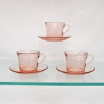 Três(03) xícaras para café com respectivos pires prensado translúcido de tonalidade rosa, manufatura Duralex. Xícaras de bojo levemente obcônico, base circular espessa, bordo liso e asas curvas aplicadas; pires circulares de cavidade central demarcada e aba lisa. Conservam marca moldada "Duralex" e indicação de fabricação brasileira no fundo das xícaras. Medidas: Xícara: Alt.: 6,5 x Comp.: 10,5 x Larg.: 8cm. ; Pires: Diam.: 13,5