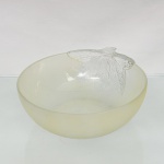 Saladeira em vidro prensado, de estética Mid-Century Modern, circa 1950- 1960. Apresenta formato hemisférico com corpo em acabamento acetinado jateado, borda superior interrompida por ornamento em relevo moldado em vidro incolor e translúcido, configurado em formato de folhagem com nervuras proeminentes que se estendem parcialmente sobre a parede interna e externa do bojo. Medidas: Alt.: 8 x Comp.: 26 x Larg.: 22,5 cm.