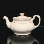 W.H. GRINDLEY, Staffordshire - Inglaterra(Fundada por William Harry Grindley em 1880). Bule para chá em faiança inglesa da década de 1940/50, padrão "Creampetal"; esmaltagem de tom marfim, decorado com frisos em douradura e tom coral, corpo bojudo de seção polilobada moldada em relevo, assente sobre base circular; tampa encimada por puxador obcônico com feitio de corola, bico vertedor curvo relevado com motivo fitomorfo, asa lateral em voluta, borda relevada com perolados e ondulações. Marca da manufatura no verso. Medidas: Alt.:  x Comp.  x Larg.:  cm.