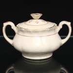 W.H. GRINDLEY, Staffordshire - Inglaterra(Fundada por William Harry Grindley em 1880). Açucareiro em faiança inglesa da década de 1940/50, padrão "Creampetal"; esmaltagem de tom marfim, decorado com frisos em douradura e tom coral, corpo bojudo de seção polilobada moldada em relevo, assente sobre base circular; tampa encimada por puxador obcônico com feitio de corola, asas laterais em voluta, borda relevada com perolados e ondulações. Marca da manufatura no verso. Medidas: Alt.:  x Diam.: cm.