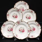 Porcellana Mauá, Mauá - SP(Fundada em 1937 por Fritz Erwin Schmidt / ativa até 1968). Conjunto de pratos fundos em porcelana nacional, c.1940-50. Formato octogonal com bordas arredondadas e debrum recortado, delimitado por filete dourado aplicado na orla. Centro decorado por motivo pictórico decalcado composto por um buquê de rosas em tons de rubi, rosa-chá e branco, guarnecido por folhagens em verde-oliva e esmeralda, que se replicam  dispostos de forma simétrica nas quatro extremidades da aba. O reverso apresenta carimbo de manufatura, contendo a inscrição em arco "Porcellana Mauá" circundando o logotipo estilizado da empresa e a representação gráfica de uma locomotiva a vapor, em referência histórica à estrada de ferro regional. Composto de seis(06) unidades. Medida: Diam.: 23 cm. Um exemplar apresenta quebraduras na borda.