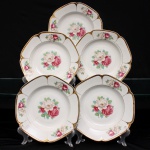 Porcellana Mauá, Mauá - SP(Fundada em 1937 por Fritz Erwin Schmidt / ativa até 1968). Conjunto de pratos fundos em porcelana nacional, c.1940-50. Formato octogonal com bordas arredondadas e debrum recortado, delimitado por filete dourado aplicado na orla. Centro decorado por motivo pictórico decalcado composto por um buquê de rosas em tons de rubi, rosa-chá e branco, guarnecido por folhagens em verde-oliva e esmeralda, que se replicam  dispostos de forma simétrica nas quatro extremidades da aba. O reverso apresenta carimbo de manufatura, contendo a inscrição em arco "Porcellana Mauá" circundando o logotipo estilizado da empresa e a representação gráfica de uma locomotiva a vapor, em referência histórica à estrada de ferro regional. Composto de cinco(05) unidades. Medida: Diam.: 23 cm.