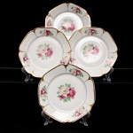 Porcellana Mauá, Mauá - SP(Fundada em 1937 por Fritz Erwin Schmidt / ativa até 1968). Conjunto de pratos rasos em porcelana nacional, c.1940-50. Formato octogonal com bordas arredondadas e debrum recortado, delimitado por filete dourado aplicado na orla. Centro decorado por motivo pictórico decalcado composto por um buquê de rosas em tons de rubi, rosa-chá e branco, guarnecido por folhagens em verde-oliva e esmeralda, que se replicam  dispostos de forma simétrica nas quatro extremidades da aba. O reverso apresenta carimbo de manufatura, contendo a inscrição em arco "Porcellana Mauá" circundando o logotipo estilizado da empresa e a representação gráfica de uma locomotiva a vapor, em referência histórica à estrada de ferro regional. Composto de quatro(04) unidades. Medida: Diam.: 24 cm.