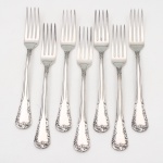 MERIDIONAL EPNS 100. Elegante conjunto de garfos grandes confeccionado em metal espessurado à prata(EPNS 100), cabo violinado com filetes longitudinais em baixo-relevo e terminação ornamentada por composição de concheados, volutas, flores e folhagens em relevo. Marca da manufatura puncionada no verso. Composto de sete(07) unidades. Medida: Comp.: 20 cm.