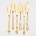 Belíssimo conjunto de facas para peixe confeccionado em metal, dotado de profusa decoração em douradura, fabricação japonesa, manufatura For Ever; cabo de ponta oval, ornamentado por composição rocaille em relevo, constituída por volutas, concheados, flores e folhagens de inspiração Luís XV. Marca da manufatura no verso do cabo. Composto de seis(06) unidades. Medida: Comp.: 18 cm.
