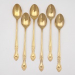 Belíssimo conjunto de colheres para chá gelado(iced tea spoon) confeccionado em metal, dotado de profusa decoração em douradura, fabricação japonesa, manufatura For Ever; cabo de ponta oval, ornamentado por composição rocaille em relevo, constituída por volutas, concheados, flores e folhagens de inspiração Luís XV. Marca da manufatura no verso do cabo. Composto de seis(06) unidades. Medida: Comp.: 19,5 cm.