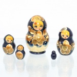 Conjunto de bonecas tradicionais russas do tipo matryoshka, confeccionado em madeira torneada e pintada à mão. Composto por cinco figuras encaixáveis de dimensões decrescentes, o grupo apresenta acabamento em verniz brilhante sobre fundo de tonalidade azul-escura uniforme, com a base da saia em tom marfim claro delimitada por semicírculos esmerilados azuis. A decoração exibe feições femininas juvenis com cílios destacados e cabelos amarelados sob lenço de cabeça (shashura) ornamentado por motivos de folhas estilizadas em tons de ocre, marrom e aplicações de purpurina dourada. O ventre das figuras principais destaca uma grande flor centralizada executada com a mesma paleta ocre e dourada, acompanhada por ramagens simples e pontilhados brancos que emulam rendas. Medidas: Alt.: 8,5 x Diam.: 4,5cm.Medidas: Alt.: 6 x Diam.: 3,5cm.Medidas: Alt.: 4,5 x Diam.: 2,5cm.Medidas: Alt.: 3 x Diam.: 2cm.Medidas: Alt.: 2 x Diam.: 1cm.