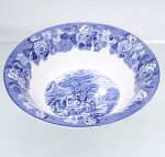 Wood & Sons, Burslem - Inglaterra(Fundada em 1865). Bowl em faiança inglesa da década de 1920. Esmaltagem vítrea na cor branca, formato hemisférico de borda levemente evertida. Dotado de profusa decoração por transferência em azul sob o vidrado, intitulada Enoch Woods English Scenery", apresentando paisagem com cena rural composta por construções campestres, figuras junto a carroça de tração animal, arvoredo, caminho e paisagem ao fundo. Aba ornamentada por friso contínuo de flores, folhagens e ramagens sobre fundo azul pontilhado. Borda contornada por friso de tonalidade azul cobalto. No verso, marca de fábrica "Enoch Woods English Scenery  Woods Ware  Wood & Sons  England". Medidas: Alt.: 7,5 x Diam.: 26 cm. Apresenta um bicado no verso da borda.