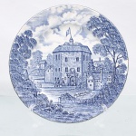 Prato decorativo em faiança de pasta dura, profuzido pela manufatura Ridgway em Staffordshire, Inglaterra, pertencente à série "Shakespeares Country", introduzida durante a segunda metade do século XX. Esmaltagem vítrea na cor branca com aba sutilmente recortada em gomos ondulares e debrum liso; superfície integralmente recoberta por ornamentação de transferência sob o vidrado em tom azul-cobalto, contendo céu anuviado e copas de árvores que se estendem pelas bordas. Centro abriga composição pictórica que reproduz uma gravação manual, retratando o edifício histórico "The Globe Theatre in the year 1599" com figuras humanas em trajes de época diante do portal, ladeado por vegetação e árvores delinfadas em hachuras. Verso exibe base com carimbo de manufatura transferido na cor azul, envolto por guirlanda floral com as inscrições "Genuine Hand Engravings EST. by Ridgway of 1792 Staffordshire England / ALL COLORS GUARANTEED UNDERGLAZE 78 AND DETERGENT PROOF / Shakespeares Country". O reverso apresenta ainda etiqueta comercial da importadora "Drohaoser Com. Ind. Ltda." com a indicação de nacionalização na Zona Franca de Manaus.  Medida: Diam.: 20 cm.