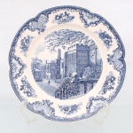 Johnson Brothers, Hanley Inglaterra(fundada em 1883 pelos irmãos Alfred, Frederick e Henry Johnson). Grande travessa circular em faiança inglesa, c1930/40, pertencente à série "Old Britain Castles". Esmaltagem vítrea de tom marfim claro, aba modelada com ligeira ondulação e orla guarnecida por cercadura geométrica contínua na cor azul. A superfície recebe ornamentação de transferência sob o vidrado em tom azul-cobalto, baseada nas matrizes gravadas em 1928 por Miss Fennel, composta por cartelas festonadas com motivos de treliças, volutas acantiformes e buquês florais. Centro abriga composição pictórica que reproduz uma gravação manual, retratando a casa senhorial fortificada de origem medieval Haddon Hall, com a inscrição inferior "Haddon Hall in 1792", detalhando personagens, fundo com céu anuviado, arcos e copas de árvores delineadas em hachuras. Verso exibe base com anel de assento aparente e carimbo de manufatura transferido na cor azul, composto por uma coroa imperial encimando as inscrições "Johnson Bros - Made in England - Old Britain Castles". Medida: Diam.: 31 cm.