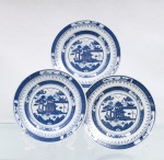 Três(03) pratos em porcelana azul e branca, China, circa 1970-80; Esmaltagem vítrea na cor branca, apresentando aba perimetral recoberta por decorações transferidas sob o vidrado em tom azul-cobalto. A ornamentação exibe o célebre padrão "Blue Willow" de inspiração oriental Chinoiserie, guarnecido por cercaduras concêntricas em padrões de reticulados geométricos, pontilhados lineares e reservas com motivos fitomórficos abstratos instalados ao longo da borda. Centro abriga composição pictórica que reproduz uma gravação, retratando cenário paisagístico composto por pagode tradicionalizado de múltiplos tetos, pontes arqueadas com personagens, embarcações navegando ao fundo, salgueiro árvores frutíferas e o pássaros em revoada na porção superior central. Reverso delimitado por duplo filete azul e marcado "Jingdezhen/ MADE IN CHINA". Produção de Jingdezhen, província de Jiangxi, República Popular da China. Segunda metade do século XX, circa 1970-1980. Medida: Diam.: 15,5 cm.