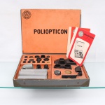 Conjunto didático de óptica "Poliopticon" - Dr. F. Vasconcellos, São Paulo, Brasil. Estojo para experiências e demonstrações de princípios de óptica, contendo componentes ópticos e respectivos suportes, entre lentes, elementos tubulares, adaptadores e acessórios para montagem de diferentes configurações experimentais. Conserva compartimentos numerados, manuais de instruções e estojo original identificado "POLIOPTICON  Dr. F. Vasconcellos  São Paulo". Conjunto de caráter didático destinado ao estudo de fenômenos ópticos.