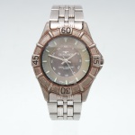 Relógio de pulso Technos, Brasil, século XX. Relógio a quartzo com caixa e bracelete articulado em metal, mostrador em tonalidade cinza, índices luminescentes, escala de minutos e três ponteiros. Bisel graduado com marcações 15, 30, 45 e 60. Mostrador assinado "Technos", com inscrições "Water Resistant", "Quartz" e 'Japan Movt." Fundo marcado Aço Inox  Prova dÁgua", referência T-206-06 / TEC 965 ZF, e "MAO Am. Ind. Bras.", indicando montagem industrial brasileira. Fecho assinado Technos. Apresenta oxidação, alterações de superfície e sinais de uso. Não está funcionando. Estado conforme forografias. Medida da caixa: Diam.: 40mm.