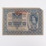 Numismática / Cédulas estrangeiras. Cédula de 1.000 Coroas (1.000 Kronen), emitida pelo Oesterreichisch-Ungarische Bank (Banco Austro-Húngaro). Anverso com valor facial 1000 disposto em cartuchos ornamentais, águia bicéfala ao centro, inscrições monetárias em diversos idiomas do Império Austro-Húngaro e efígie feminina em medalhão à direita. Apresenta sobrecarga DEUTSCHÖSTERREICH, aplicada após a dissolução do Império Austro-Húngaro para validação da cédula na República da Áustria Alemã. Numeração 67556 / 2730. Data impressa: 2 de janeiro de 1902. Reverso com composição ornamental em guilhochês, dois retratos femininos em medalhões laterais e valor facial 1000 repetido.