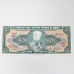 Numismática / Cédulas do Brasil. Cédula de 2 Cruzeiros (Cr$ 2,00), pertencente ao padrão monetário brasileiro do Cruzeiro, emissão do Tesouro Nacional. Estampa 2A, Série 740A, número de ordem 092715, impressa por Thomas De La Rue & Company Limited, Londres. Anverso com efígie de Luís Alves de Lima e Silva, Duque de Caxias, em medalhão central, ladeada pelo valor facial 2, inscrições República dos Estados Unidos do Brasil, Tesouro Nacional e Dois Cruzeiros  Valor Recebido, além das chancelas das autoridades monetárias. Reverso com representação da Escola Militar de Resende, atual Academia Militar das Agulhas Negras, ladeada por cartuchos com o valor facial. Impressão sobre papel fiduciário.