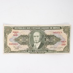Numismática / Cédulas do Brasil. Cédula de 10 Cruzeiros (Cr$ 10,00), pertencente ao padrão monetário brasileiro do Cruzeiro, emissão do Tesouro Nacional. Estampa 2A, Série 3478A, número de ordem 063515, impressa por Thomas De La Rue & Company Limited, Londres. Anverso com efígie de Getúlio Vargas em medalhão central, ladeada pelo valor facial 10, inscrições República dos Estados Unidos do Brasil, Tesouro Nacional e Dez Cruzeiros  Valor Legal, além das chancelas das autoridades monetárias. Reverso com alegoria da Unidade Nacional, representada por trabalhador manejando ferramenta industrial, tendo instalações fabris ao fundo, ladeada por cartuchos com o valor facial. Impressão calcográfica e tipográfica sobre papel fiduciário. Brasil, década de 1950.