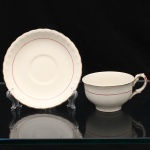 W.H. GRINDLEY, Staffordshire - Inglaterra(Fundada por William Harry Grindley em 1880). Xícara para chá em faiança inglesa da década de 1940/50, padrão "Creampetal"; esmaltagem de tom marfim, decorado com frisos em douradura e tom coral, bojo hemisférico sobre base circular, asa lateral em voluta, borda do pires relevada com perolados e ondulações. Marca da manufatura no verso. Medidas: Xícara: Alt.: 5,5 x Comp. 12 x Larg.: 9,5 cm; Pires: Diam.: 14,5 cm.