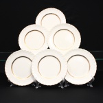 W.H. GRINDLEY, Staffordshire - Inglaterra(Fundada por William Harry Grindley em 1880). Conjunto de pratos rasos em faiança inglesa, padrão "CREAMPETAL", c.1940-50. Esmaltagem vítre de tonalidade marfim claro, orla modelada com faixa perimetral ondulada, percorrida por perolados relevados na própria pasta, ornamentada por filetagem à ouro contornando a borda e a caldeira. Apresenta ínfimos degastes de uso na douradura. Marca da manufatura no verso. Composto de seis(06) unidades. Medida: Diam.: 23 cm.