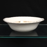 W.H. GRINDLEY, Staffordshire - Inglaterra(Fundada por William Harry Grindley em 1880). Bowl em faiança inglesa, padrão "CREAMPETAL", c.1940-50. Esmaltagem vítrea de tonalidade marfim claro, formato hemisférico, orla modelada com faixa perimetral ondulada, percorrida por perolados relevados na própria pasta, ornamentada por filetagem à ouro contornando a borda e a caldeira, abas laterais integradas e decoradas com ramagens. Marca da manufatura no verso. Medidas: Alt.: 6,5 x Diam.: 25 cm.