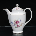 Porcelana Real, Mauá - SP(Fundada em 1943 por Fritz Erwin Schmidt). Belíssimo bule para café executado em porcelana nacional, circa 1960-1970. Bojo oval alongado assente sobre base circular, tampa abaulada encimada por puxador aproximadamente cônico, asa lateral em voluta. Esmaltagem vítrea na cor branca, ornamentação com motivos pictóricos policromados por processo de decalcomania fina inspirados no estilo "Deutsche Blumen", distribuídos pelo bojo e no topo da tampa, realçada por filetagem à ouro nas bordas e margens. Marca da manufatura ao fundo. Medidas: Alt.: 21,5 x Comp.: 24,5 x Larg.: 12 cm.
