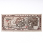 Numismática / Cédulas do Brasil. Cédula de 5 Cruzeiros, Estampa 3, Série 077, emitida pela República dos Estados Unidos do Brasil e impressa pela Casa da Moeda do Brasil no contexto da implantação do padrão monetário Cruzeiro, instituído em 1942 após a reforma que substituiu o sistema do réis. Anverso apresenta composição dominada por busto feminino alegórico representando a República, voltado à esquerda e inscrito em medalhão oval, tendo ao fundo vinheta marítima com embarcação à vela singrando mar agitado, elemento simbólico associado ao progresso econômico, à navegação e ao comércio. No campo central destaca-se elaborada cartela ornamental com o numeral 5 e a legenda CRUZEIROS, envolta por complexa trama de guilhochê de segurança característica da gravura calcográfica. Consta ainda a inscrição legal No Tesouro Nacional se pagará ao portador desta quantia de cinco cruzeiros, acompanhada das assinaturas fac-similares das autoridades monetárias e da indicação tipográfica Estampa 3 Série 077 impressa em vermelho. O reverso exibe vinheta naturalista representando vitória-régia (Victoria amazonica) em paisagem lacustre amazônica, com grandes folhas circulares flutuantes e flor central, enquadrada por moldura ornamental geométrica com os numerais 5 nos cantos e a legenda Estados Unidos do Brasil. Impressão calcográfica com fundos guilhochados de segurança e gravação em aço, padrão característico da produção da Casa da Moeda brasileira nas décadas de 19401950. Exemplar em estado aproximado MBC (Muito Bem Conservado), apresentando vincos de circulação, porém com papel íntegro e boa definição da gravura.