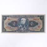 Numismática / Cédulas do Brasil. Cédula de 2 Cruzeiros, República dos Estados Unidos do Brasil, Série 583A, número 053734. Anverso com impressão predominante em tonalidade azul-acinzentada, com efígie do Duque de Caxias em medalhão central, ladeada por rosáceas com o valor facial 2; inscrições Tesouro Nacional, República dos Estados Unidos do Brasil e Dois Cruzeiros  Valor Recebido. Reverso com impressão predominante em tonalidade laranja, apresentando vista aérea da Escola Militar de Resende, atual Academia Militar das Agulhas Negras, ladeada por elementos ornamentais e algarismos indicativos do valor facial. Impressão pela American Bank Note Company. Brasil, década de 1950.