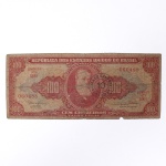 Numismática / Cédulas do Brasil. Cédula de 100 Cruzeiros, República dos Estados Unidos do Brasil, 2ª Estampa, Série 506A, número 060488. Anverso em tonalidades vermelha, vermelho-rosada, bege e verde-azulada, com efígie de D. Pedro II em medalhão central, ladeada por rosáceas com o valor facial 100; inscrições Tesouro Nacional, República dos Estados Unidos do Brasil e Cem Cruzeiros  Valor Legal. Apresenta carimbo circular de revalidação monetária do Banco Central, com a inscrição BANCO CENTRAL  10 CENTAVOS, aplicada em 1967 para conversão do valor original de 100 Cruzeiros em 10 centavos de Cruzeiro Novo. Reverso em tonalidade vermelho-rosada, com composição alegórica da Cultura Nacional, representada por figura feminina sentada junto a globo, livros e instrumentos, tendo paisagem ao fundo. Impressão pela Thomas De La Rue & Company Limited, Londres. Brasil, circa 1953-1959; revalidada em 1967. Estado de conservação conforme fotografias.
