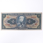 Numismática / Cédulas do Brasil. Cédula de 2 Cruzeiros, República dos Estados Unidos do Brasil, Série 851A, número 047660. Anverso com impressão predominante em tonalidade azul-acinzentada, com efígie do Duque de Caxias em medalhão central, ladeada por rosáceas com o valor facial 2; inscrições Tesouro Nacional, República dos Estados Unidos do Brasil e Dois Cruzeiros  Valor Recebido. Reverso com impressão predominante em tonalidade laranja, apresentando vista aérea da Escola Militar de Resende, atual Academia Militar das Agulhas Negras, ladeada por elementos ornamentais e algarismos indicativos do valor facial. Impressão pela American Bank Note Company. Brasil, década de 1950.